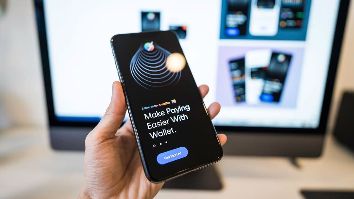 A hand holding a smartphone showing a digital e-wallet app's home screen